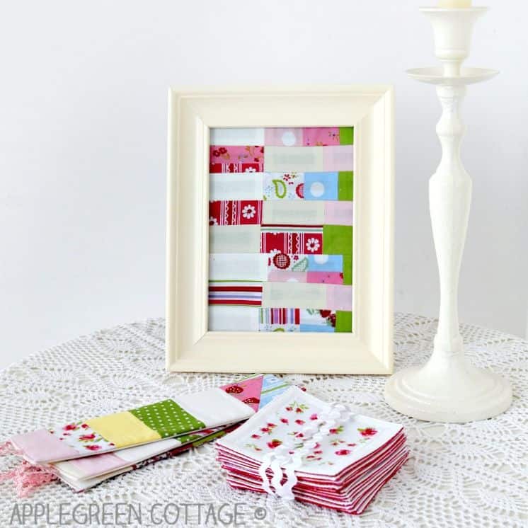 framed fabric patchwork and other items made of fabric, placed on a white, doily-covered side table