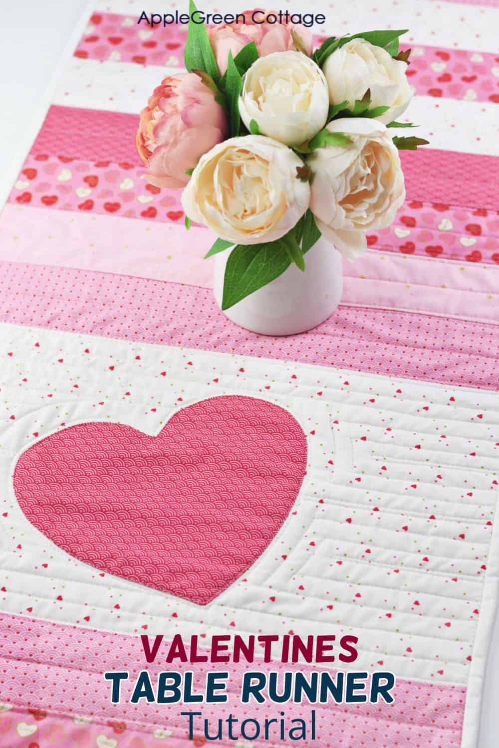 A beautiful quilted table runner in shades of pink, red, and white, adding a touch of love and warmth to any table setting