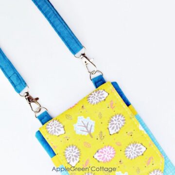 a small handmade cell phone bag with adjustable straps made with blue fabric