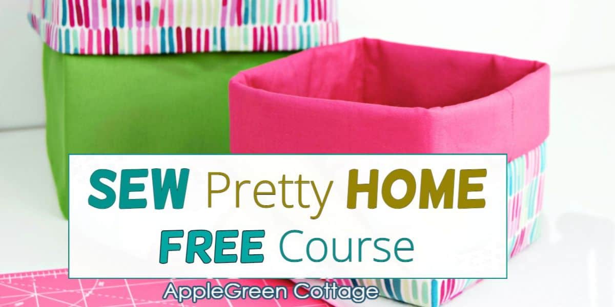 Two handmade fabric baskets with folded edges in bright green and pink cotton prints, placed on a sewing table.