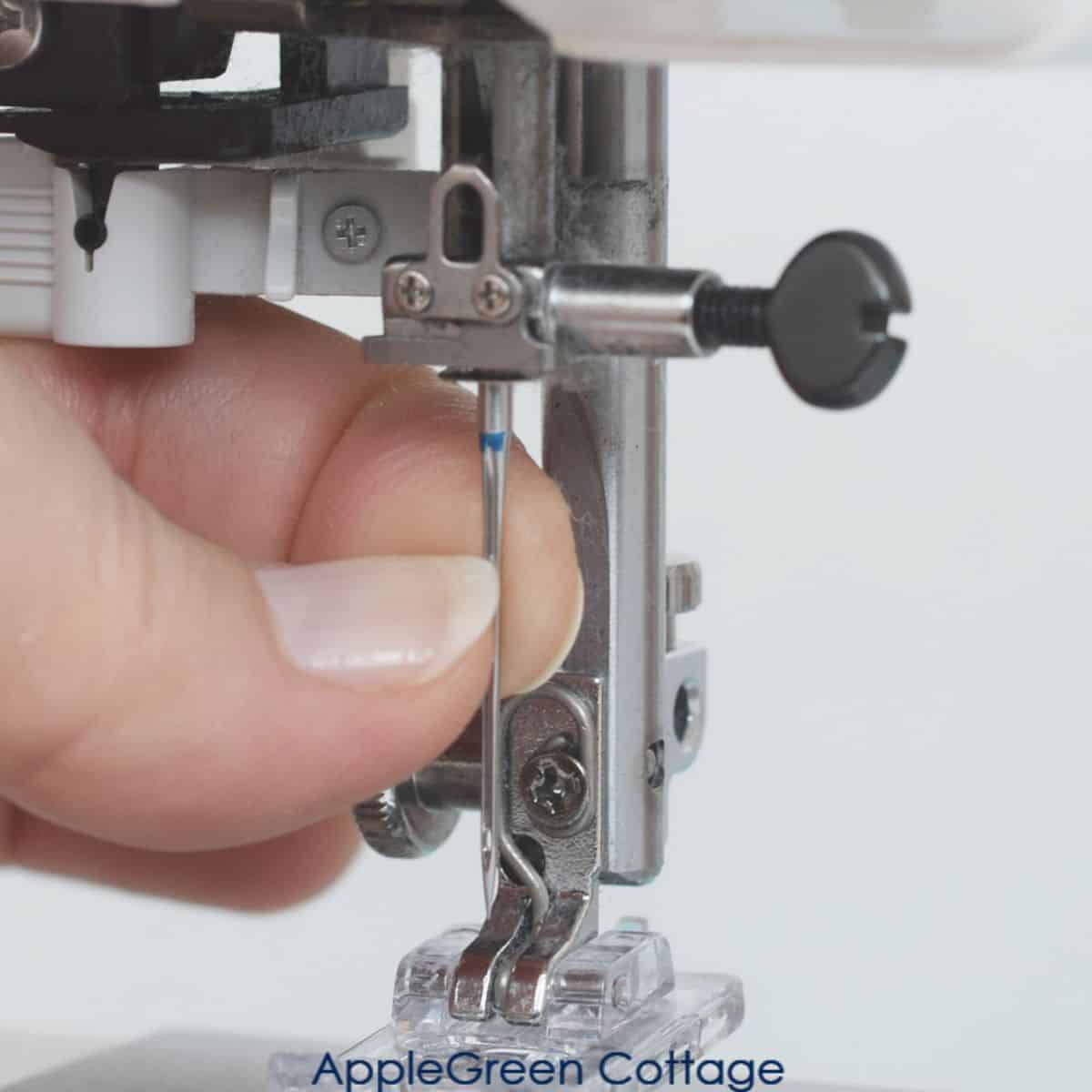 a schmetz sewing machine needle being pushed into the needle holder on a sewing machine