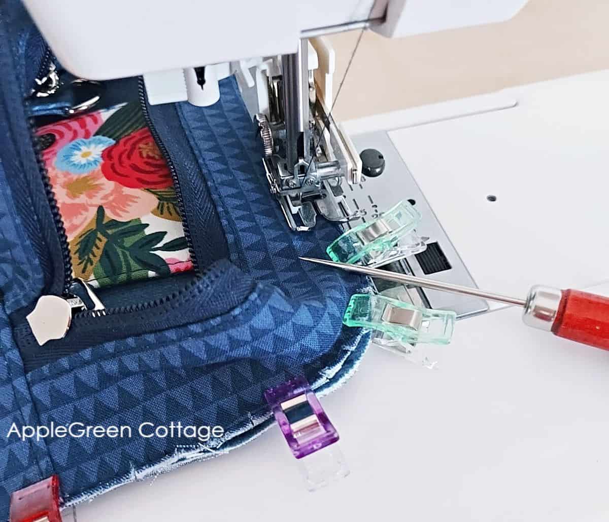 A Janome HD sewing machine sewing over multiple layers of fabric and bagmaking interfacing.