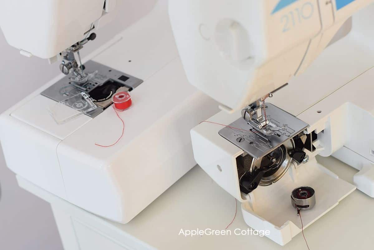 two sewing machines showing the part where the bobbin compartments are positioned, one showing a front-load bobbin case, and the second one showing a top-load bobbin case 