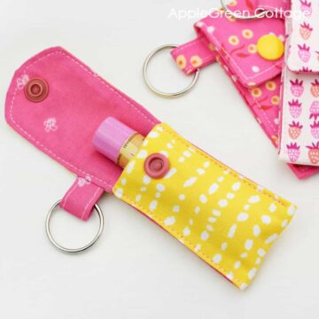 a finished yellow and pink fabric chapstick holder keychain with a top closure and a snap