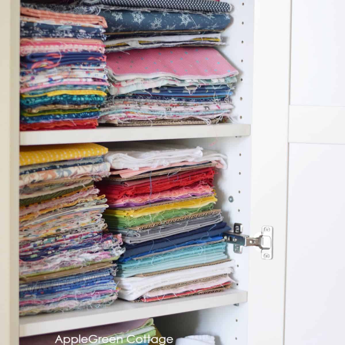 fabric stash stacked on wardrobe closet shelves, with diy cardboard dividers