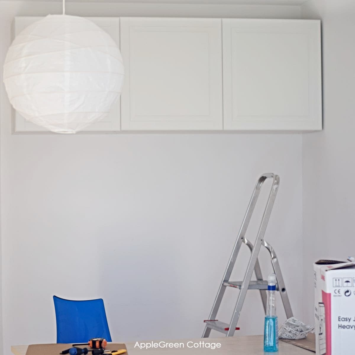 sewing room storage makeover with a hanging shelving unit for storage of crafts materials