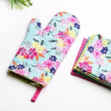 a finished quilted fabric oven mitt on a flat surface, featuring a beautiful floral print