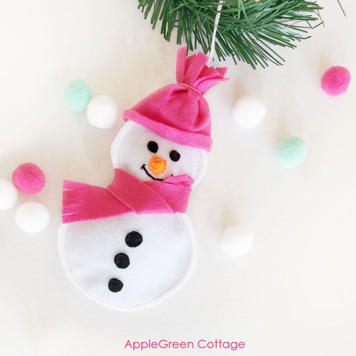 finished felt snowman ornament, decorated with a pink felt cap and scarf