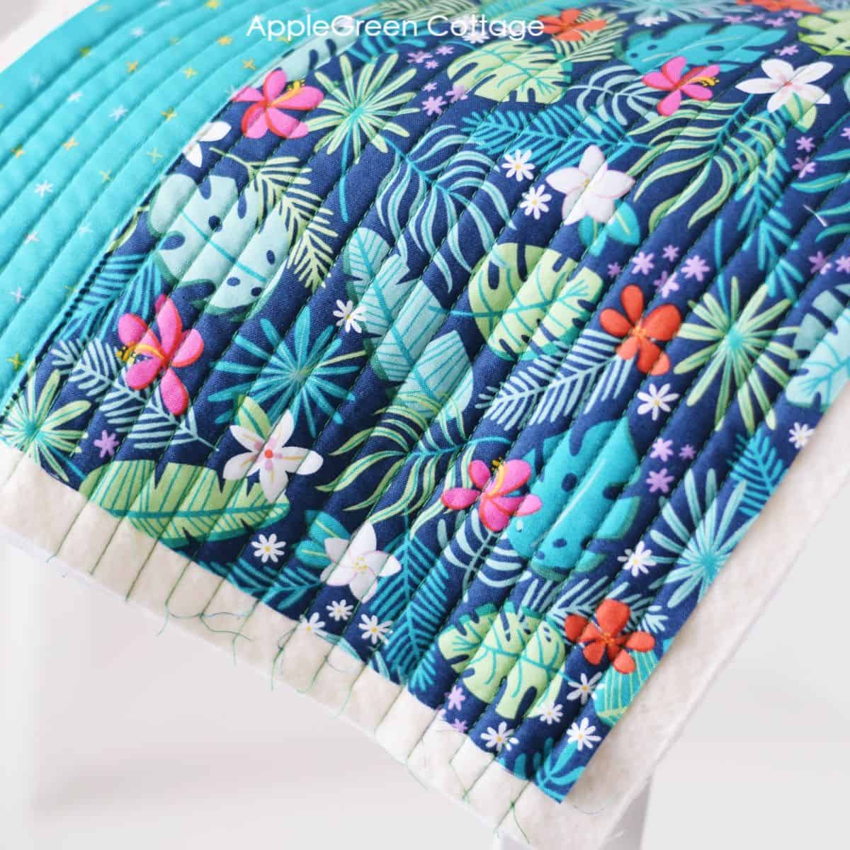 Straight line quilting design on floral fabric.