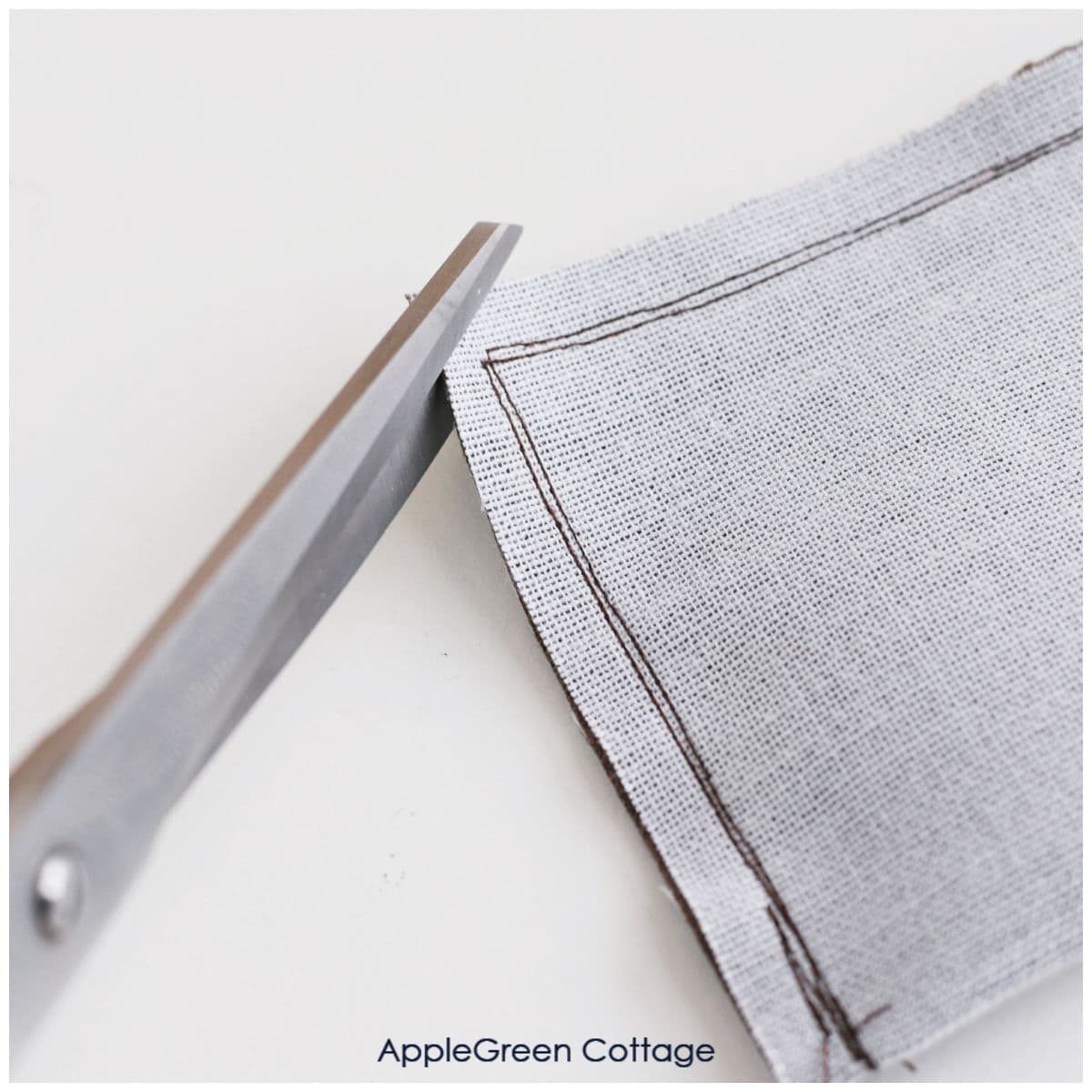 scissors cutting of a corner from the seam allowancce on a sewn piece of faux suede