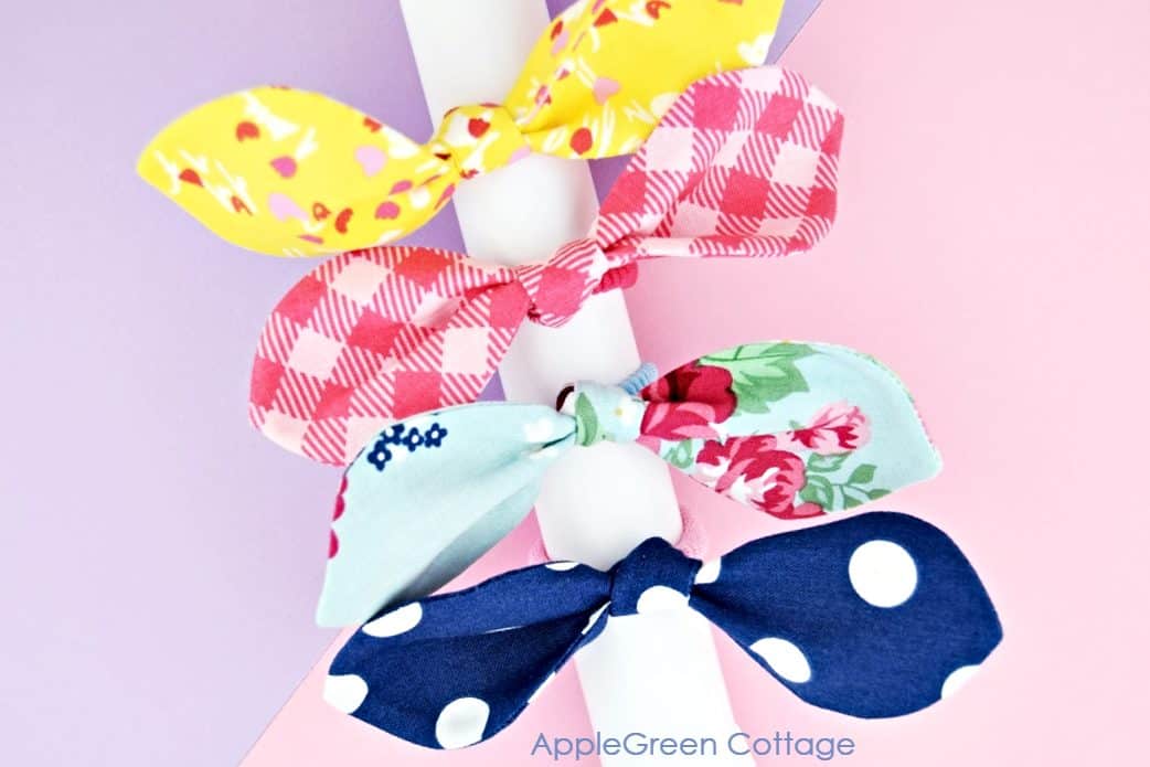 finished fabric hair ties on a paper roll and with a pastel pink background