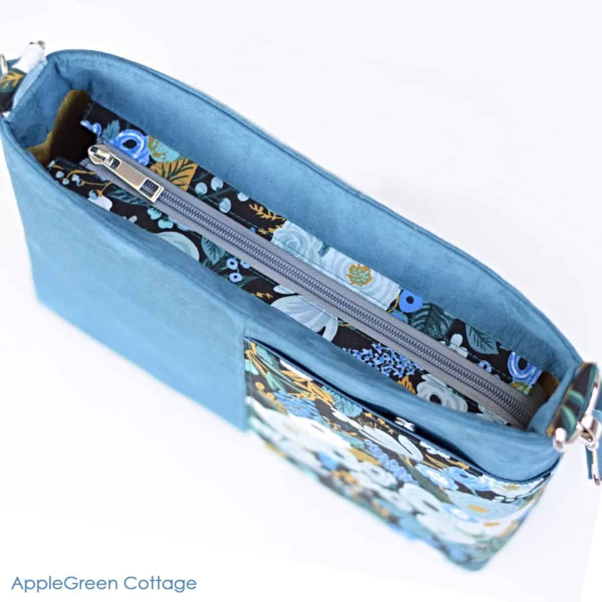 a finished purse with an inset zipper panel at the top and a front cell phone pocket