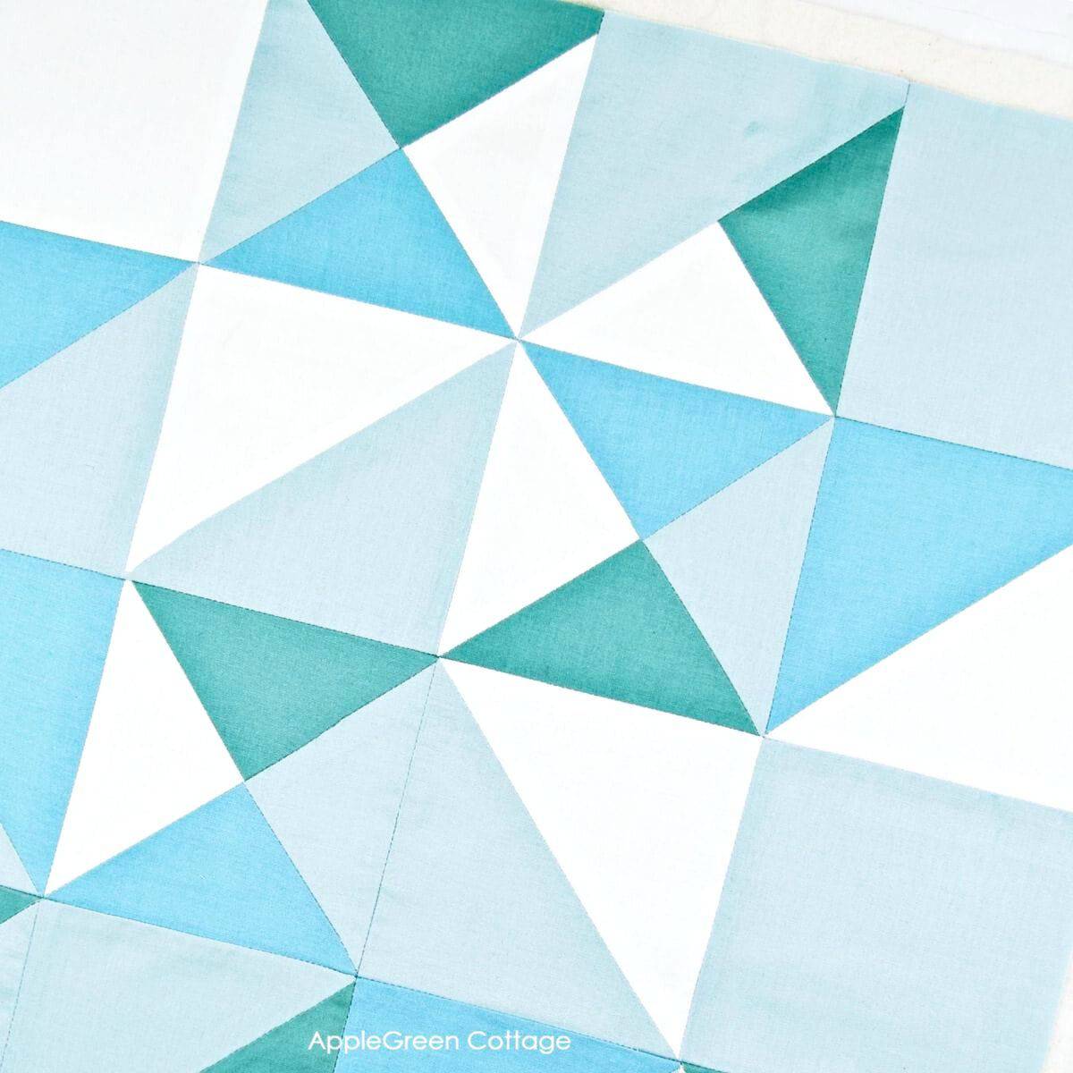 an aqua, teal and white fabric quilt blocks , full squares, and HST blocks pieced together into a modern quilt design