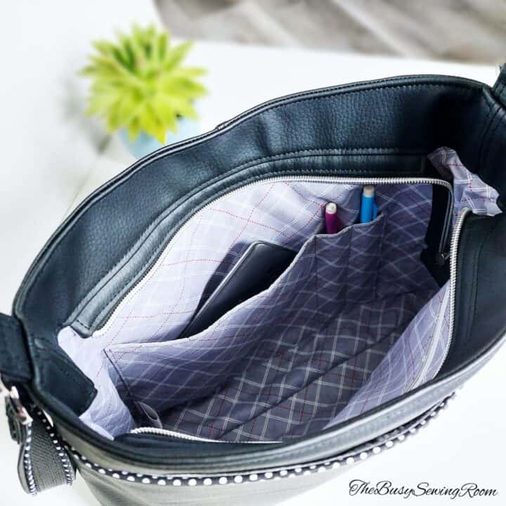 a handmade bag sewn with with black faux leather, showing a slip pocket in lining and two pencil pockets