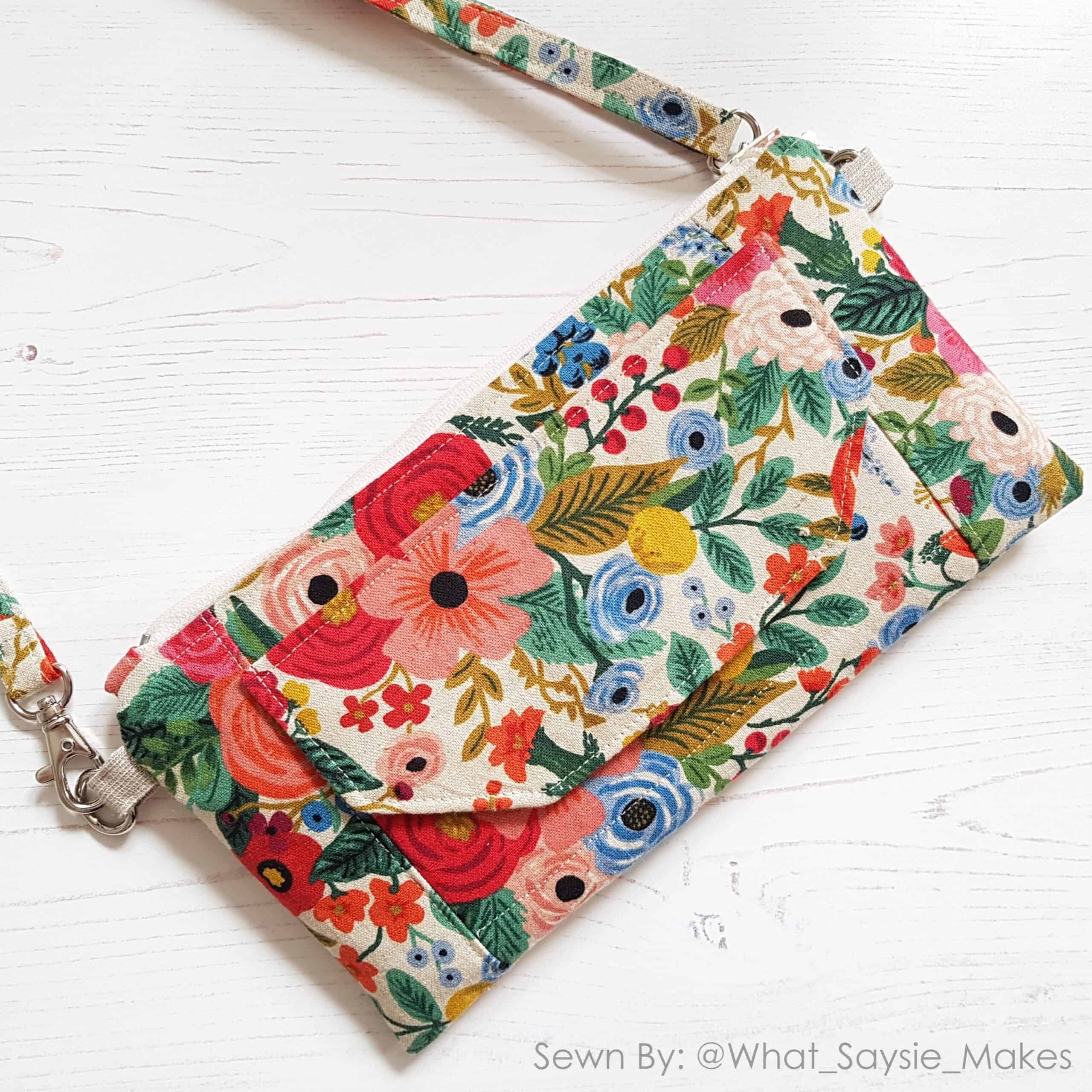a beautiful handmade wallet bag in floral riflepaperco prints with a flap and a crossbody strap