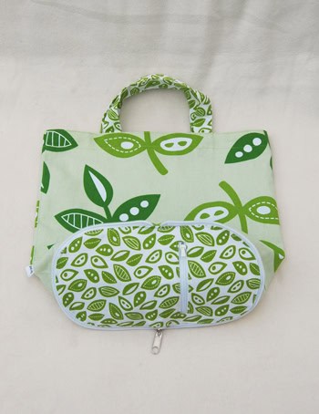 a white and green canvas tote bag that converts into a wallet