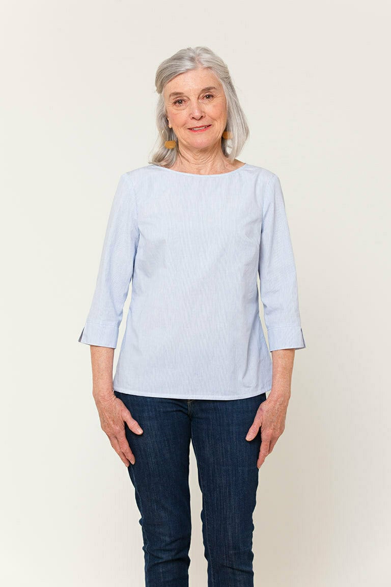 a woman wearing a finished woven boatneck top in light blue