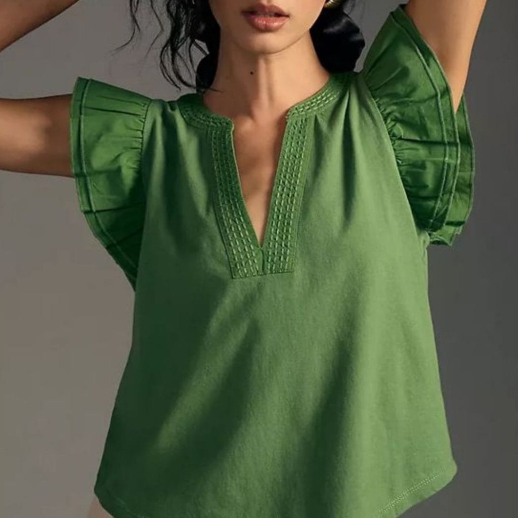 a woman wearing a womens top with ruffle sleeves in light green