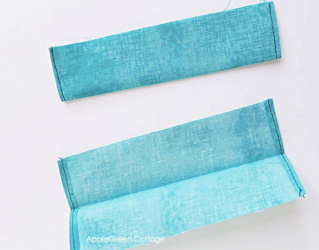 how to sew casing for drawstring bag two rectangluar fabric pieces cut to make a casing in a drawstring water bottle holder