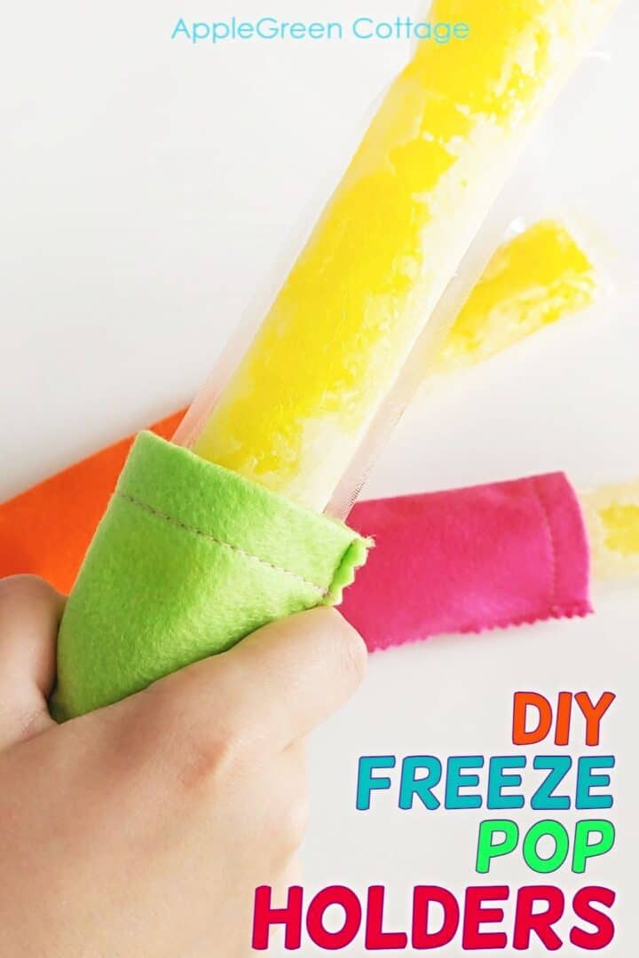 a child hand holding a homemade ice pop in a diy freeze pop holder made out of green felt