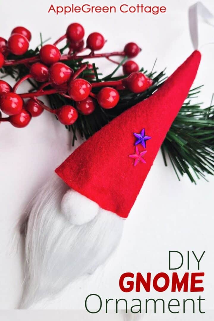 a finished handmade Christmas gnome ornament placed on holiday greenery