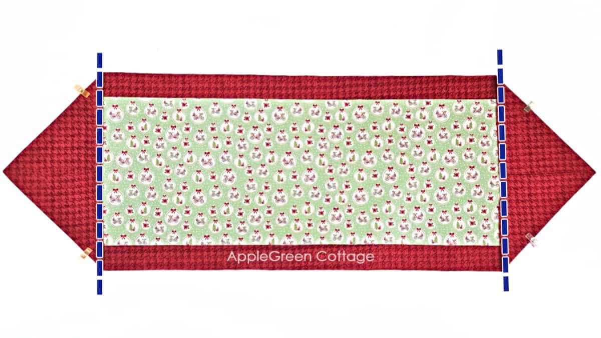 a finished fabric table runner sewn with two fabric pieces in Christmas prints