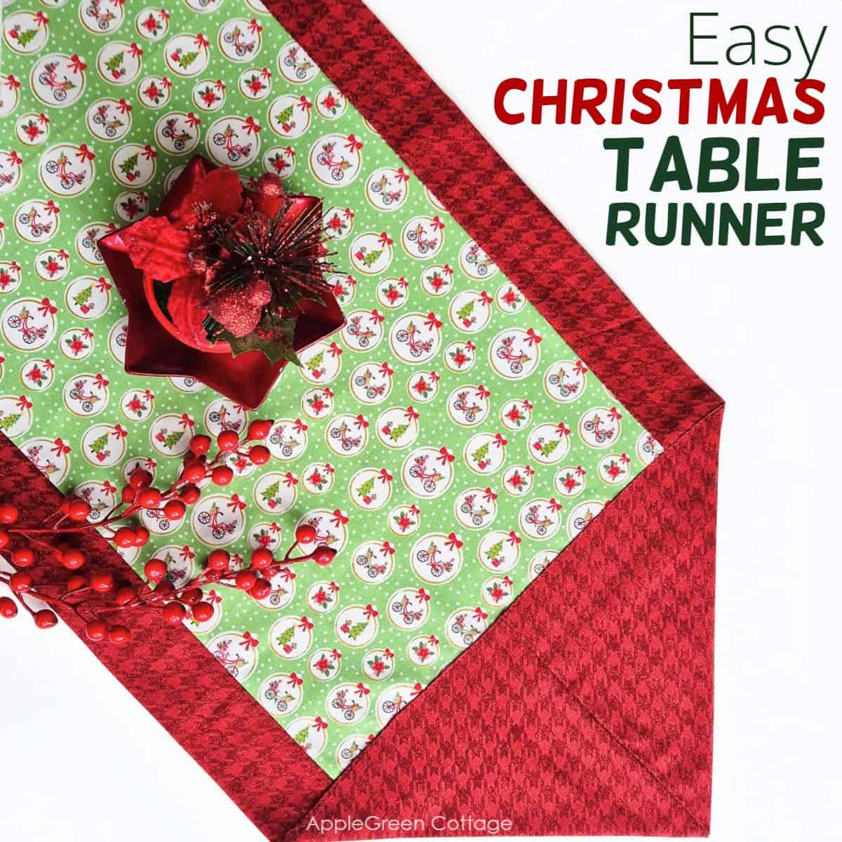 a finished fabric table runner sewn with two fabric pieces in Christmas prints, with a red glossy star-shaped plate on it and 2 stems of holly red berries