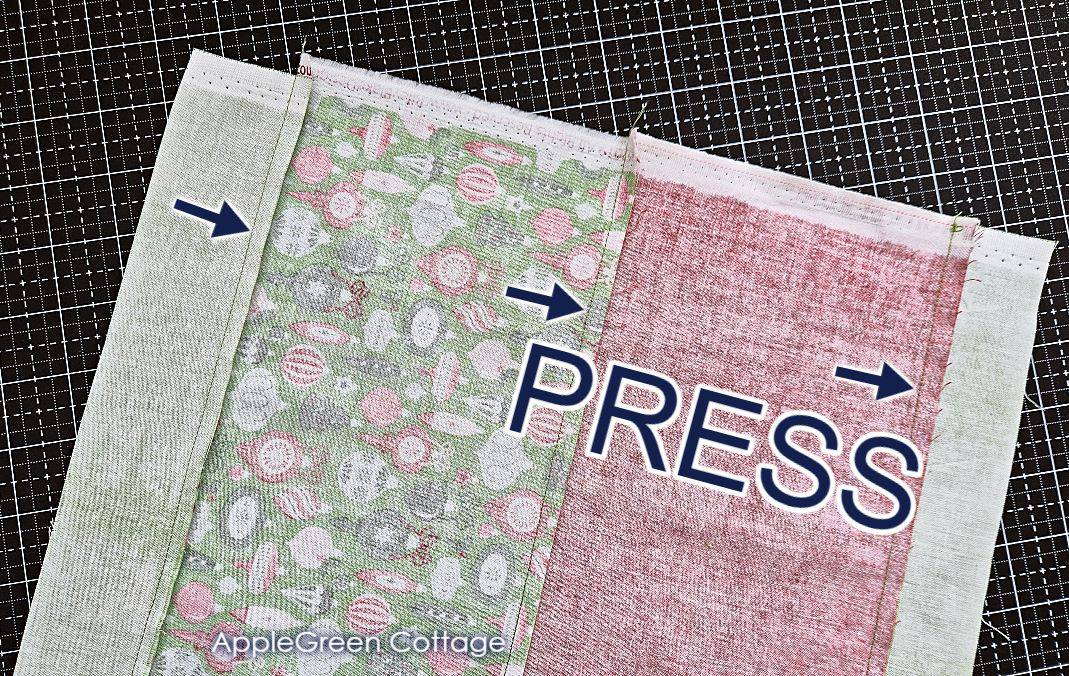 strip-pieced cotton with the seam allowances pressed in one direction, placed on a balck cutting mat