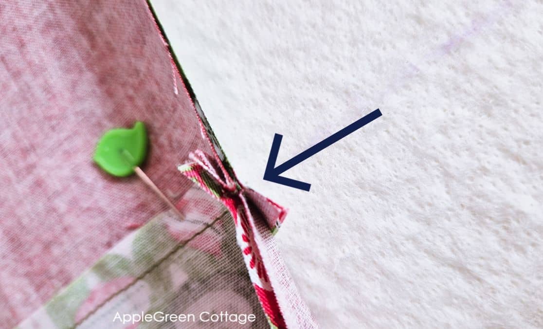 two quilt blocks pinned together for sewing, with nested seams
