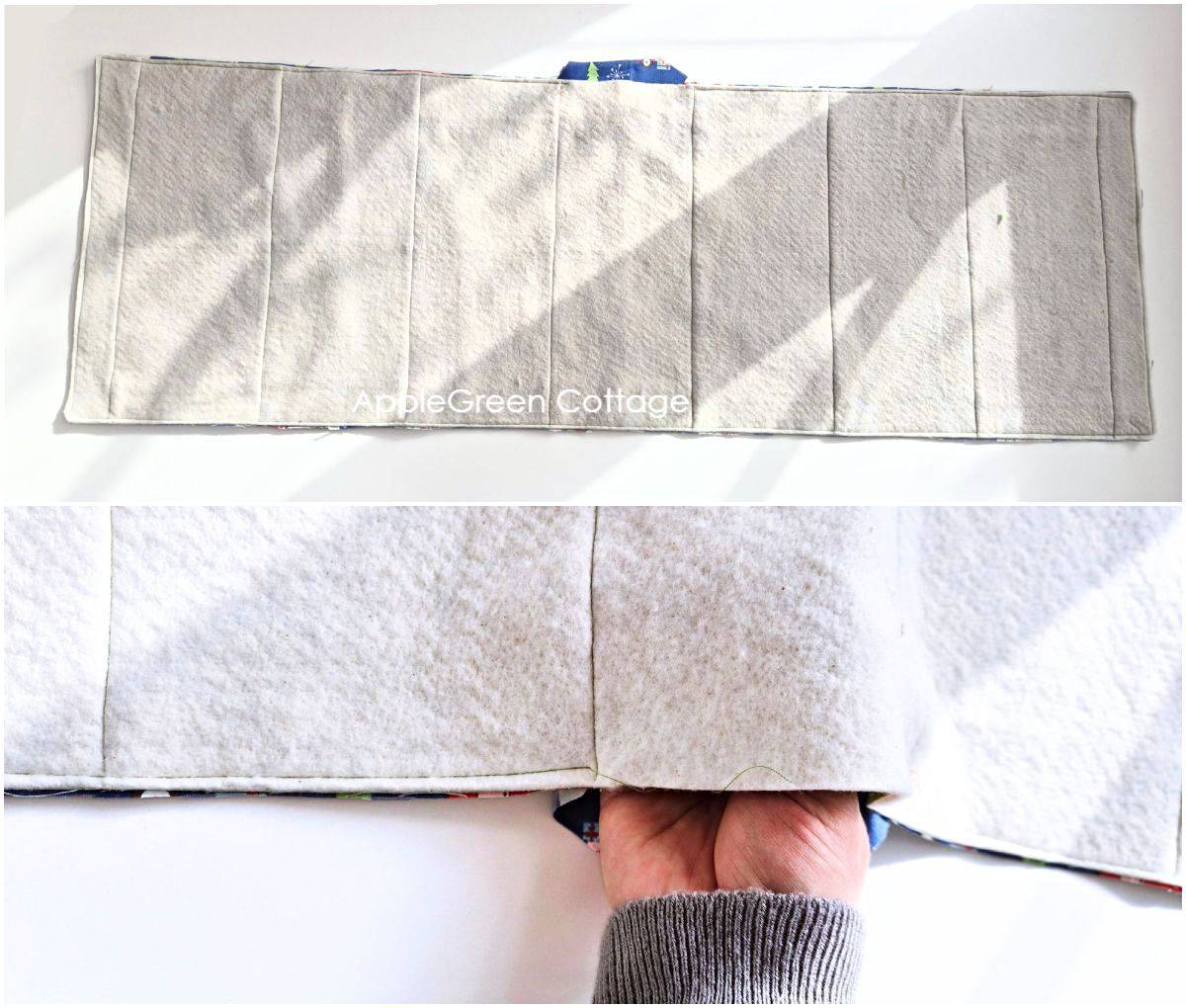 a hand holding a semi-finished table runner with batting on top