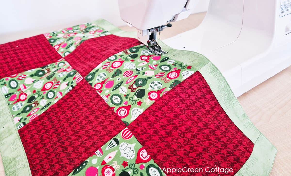 sewing machine with a table runner featuring red and green christmas prints