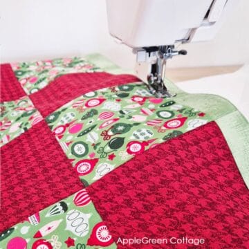 sewing machine with a table runner featuring red and green christmas prints