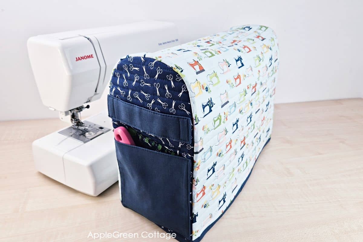 Completed quilted sewing machine cover pattern featuring colorful prints and storage pockets.