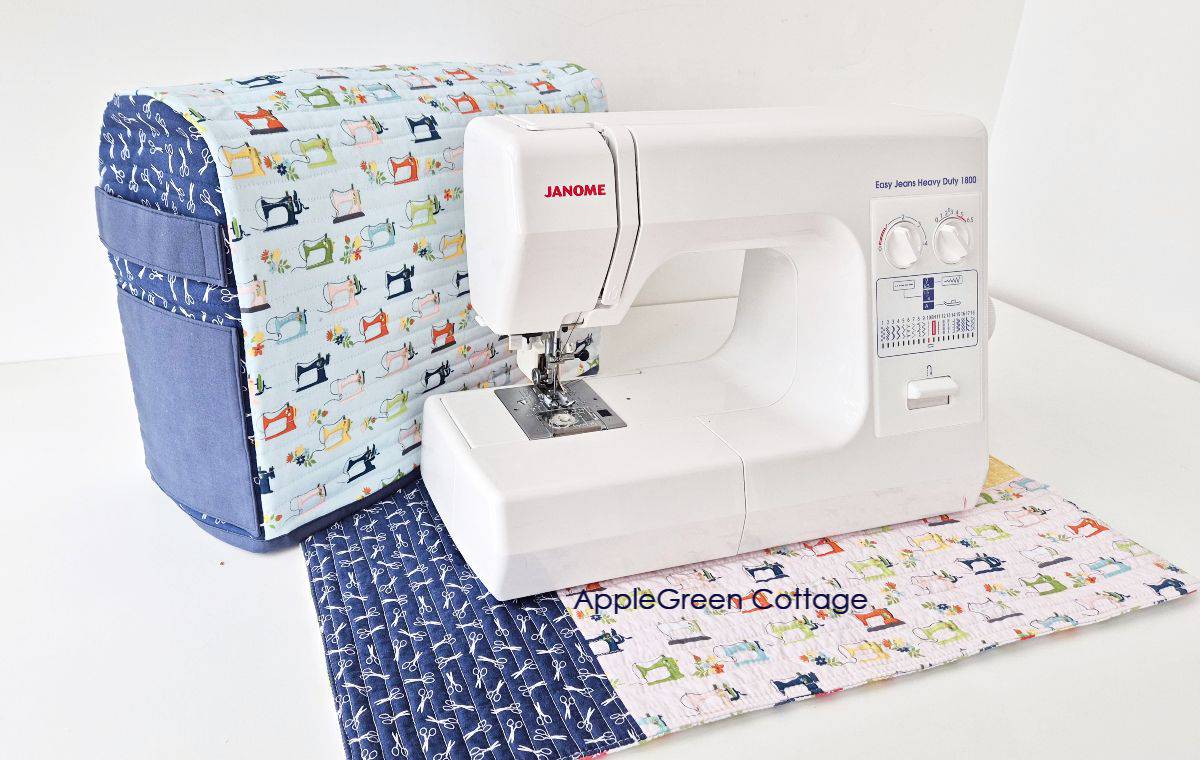 Finished sewing machine cover pattern paired with a sewing machine mat and a Janome sewing machine on display.