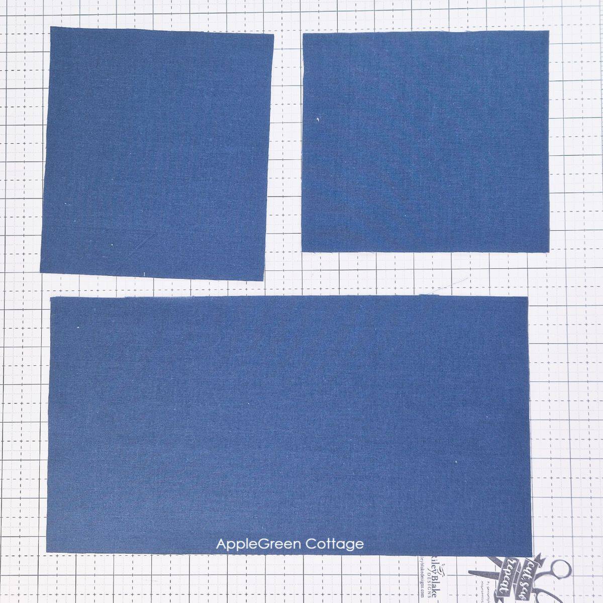Cut fabric pieces laid out for creating a custom sewing machine cover pattern.