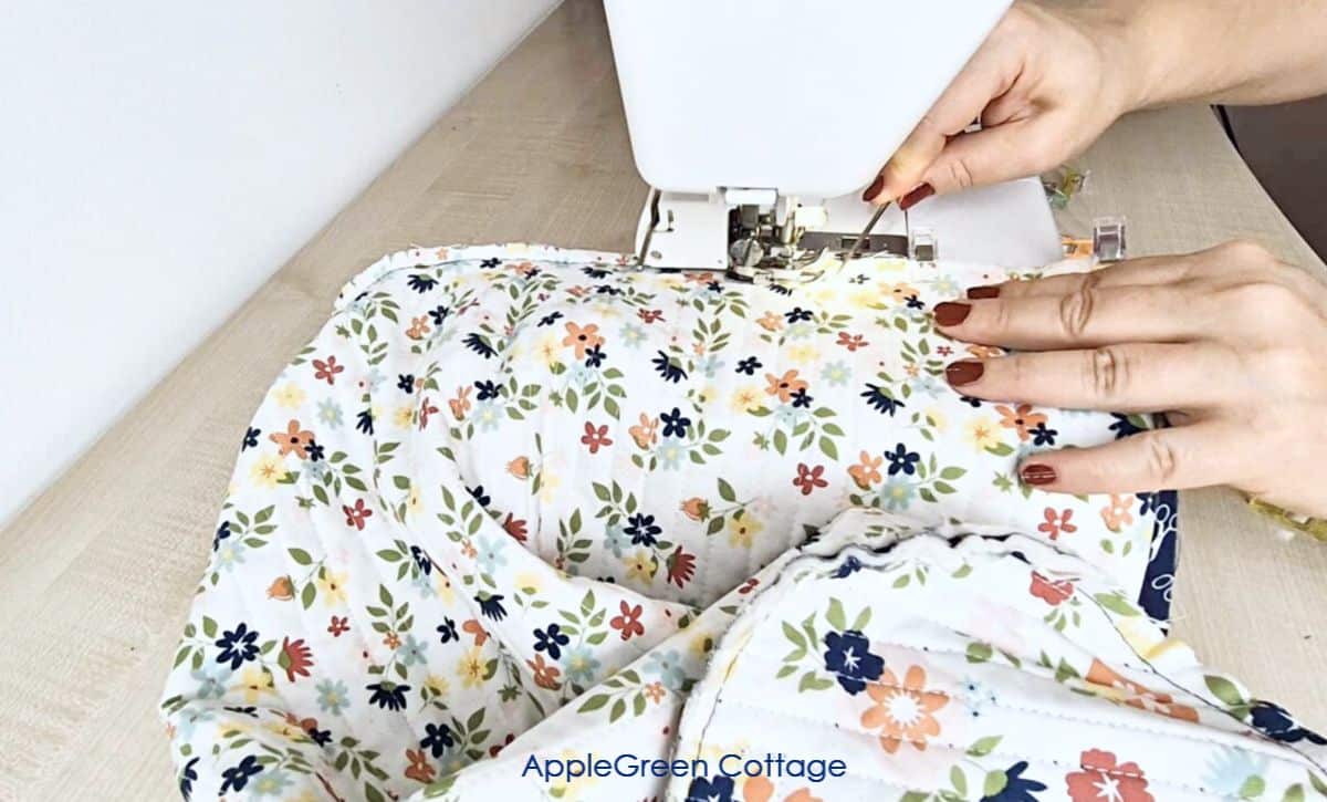 Quilting the layered panels for a sewing machine cover pattern with a vibrant design.