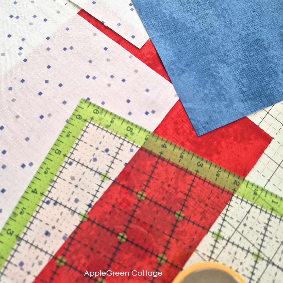 A colorful display of quilting rulers paired with red, blue, and white fabrics. Ideal for creating accurate cuts and stunning quilt designs.