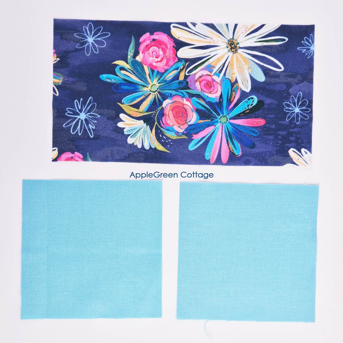 Three fabric pieces arranged for a 1-seam flying geese block. A floral rectangle and two blue squares, ready for assembly.