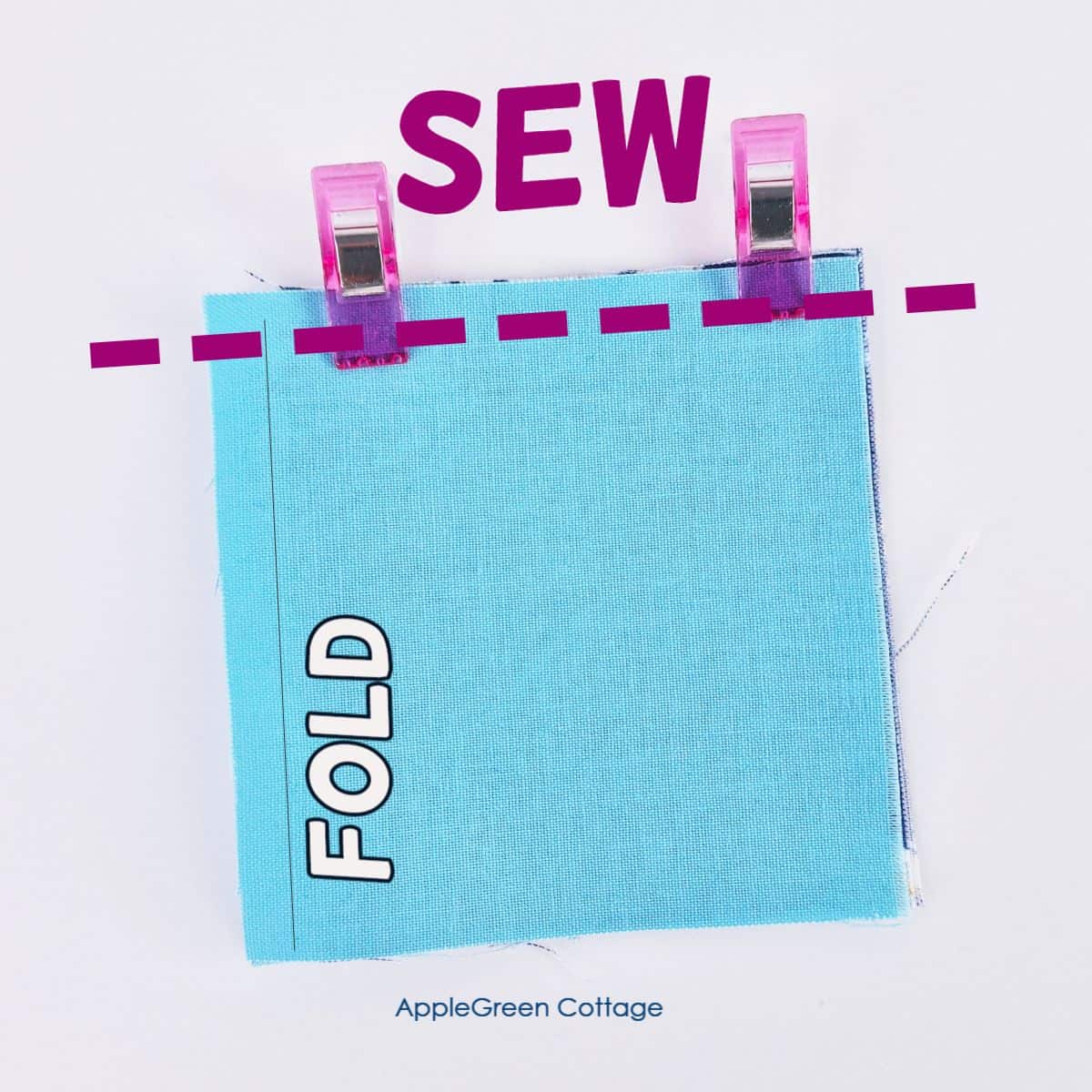 A fabric square folded in half, clipped at the top, with the word 'SEW' above a dotted sewing guideline.