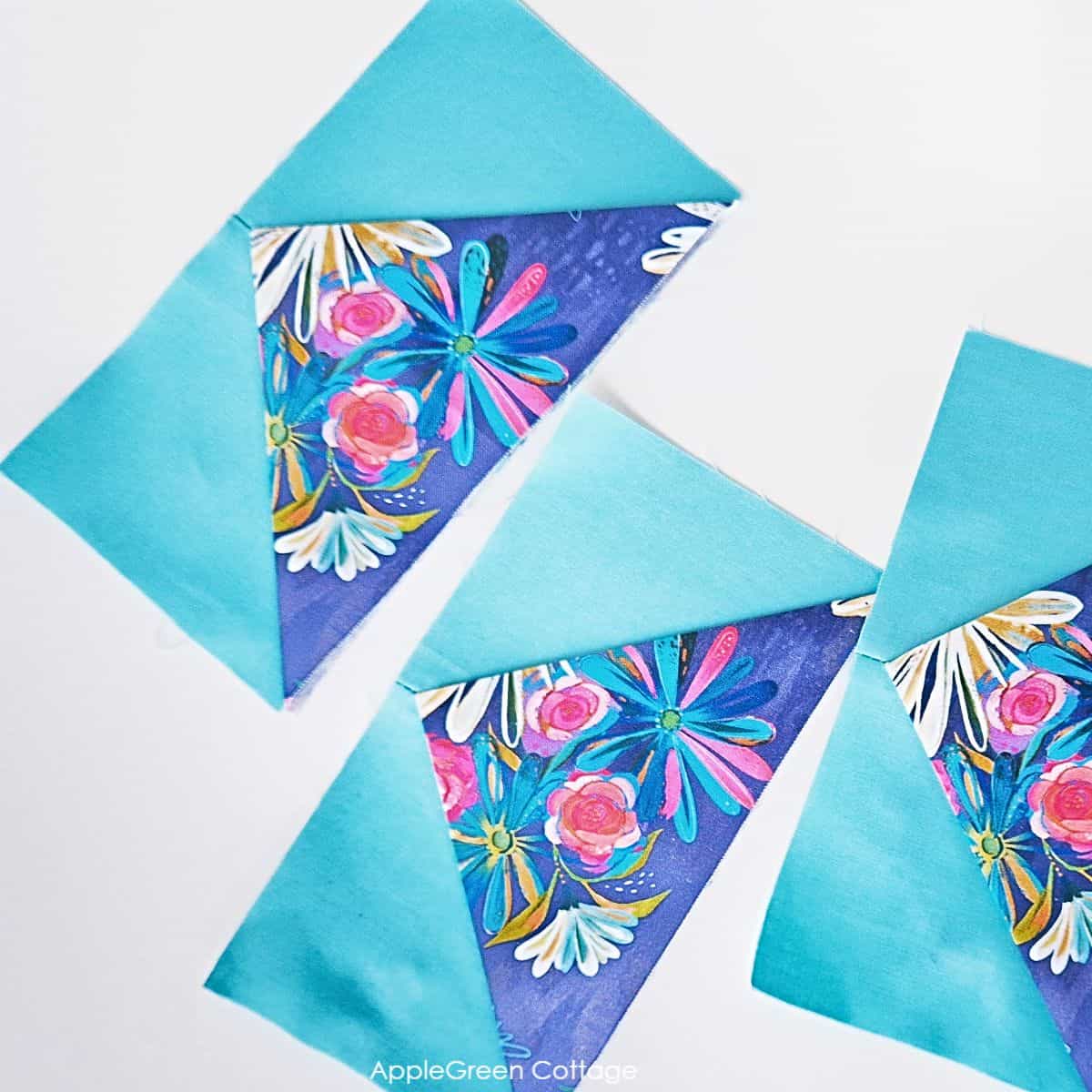 Scattered one-seam flying geese quilt blocks in floral and blue fabrics, showcasing a creative layout for modern quilting designs.