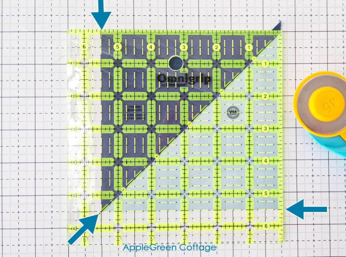 Trimming HST blocks for precise seam allowances in quilting.