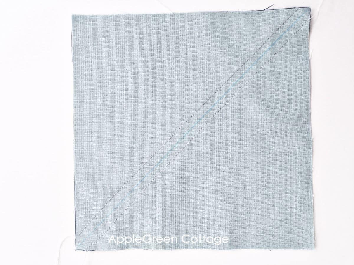 Sewn Half Square Triangle block with a diagonal seam for quilting.