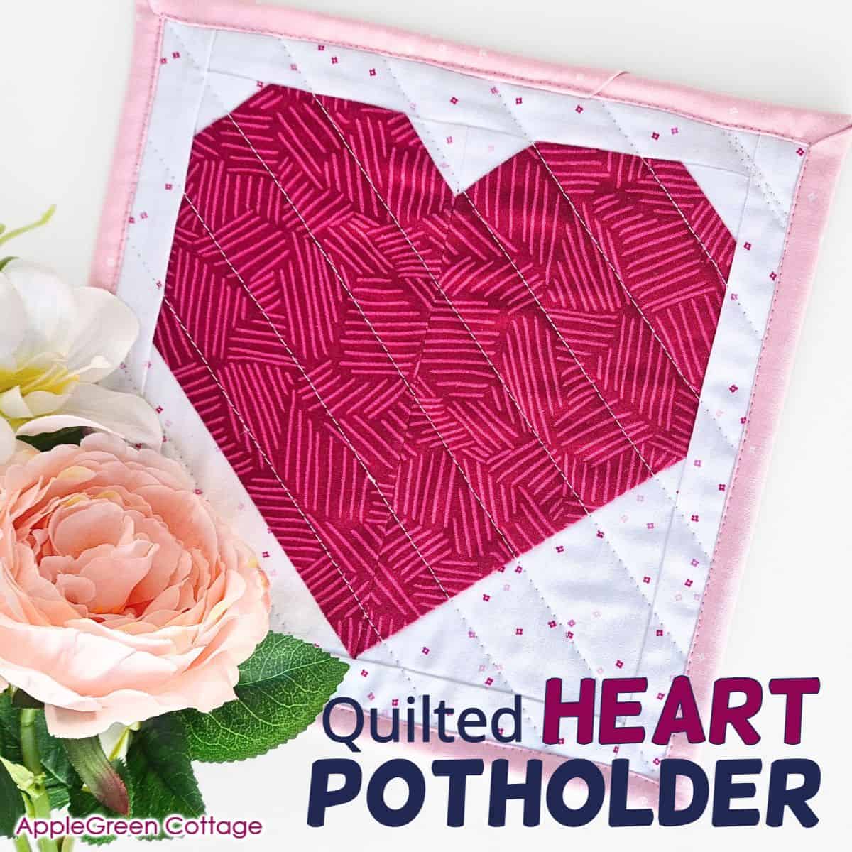 Close-up of a completed pink heart quilt block with floral details, showcasing a beginner-friendly sewing project.