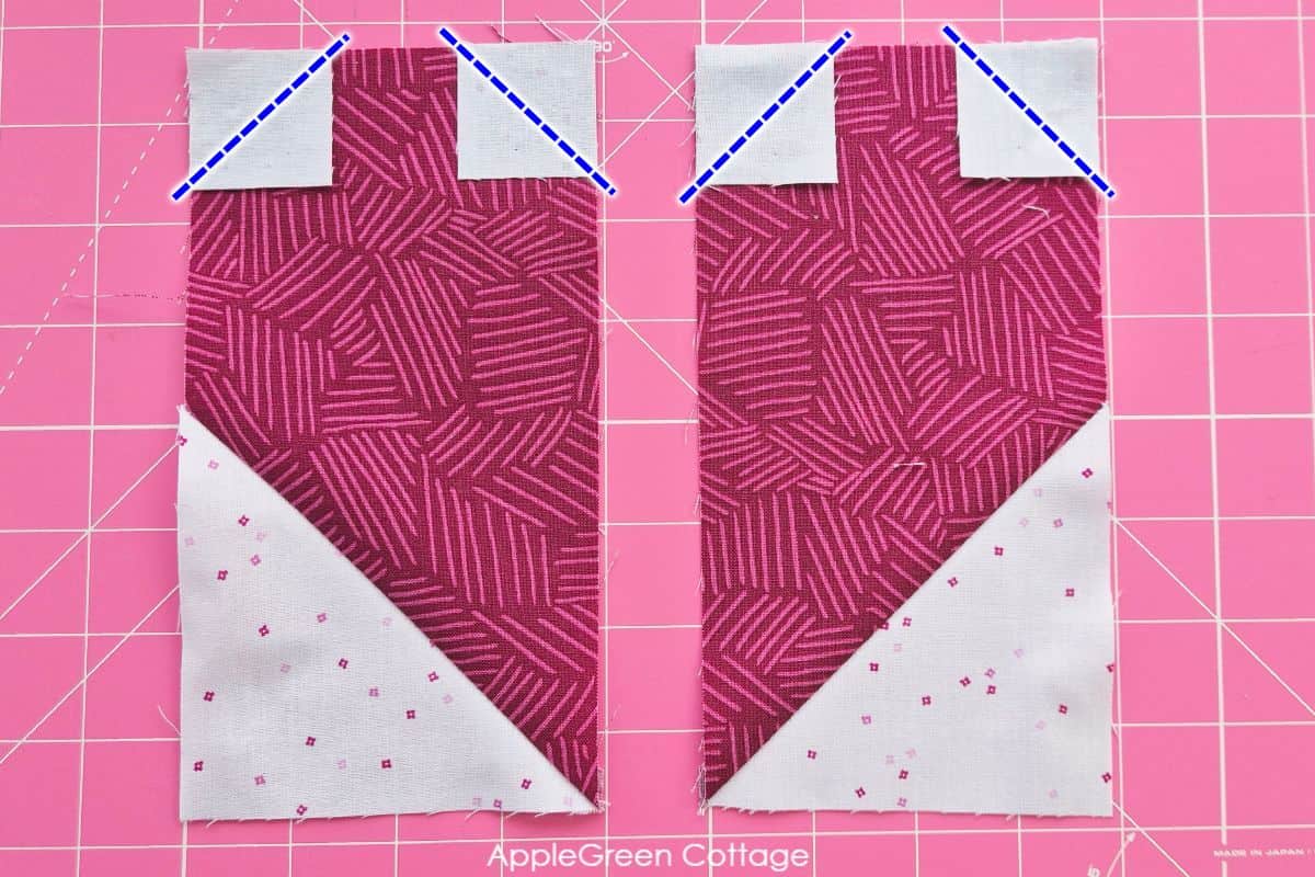 Adding small white squares to the top corners of the heart quilt block fabric for precise shaping.