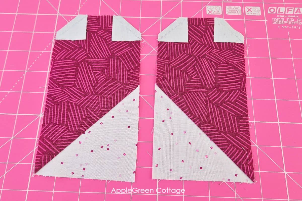 Adding small white squares to the top corners of the heart quilt block fabric for precise shaping.