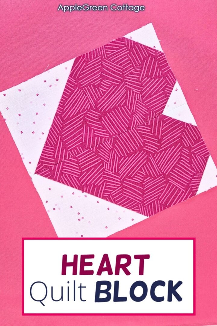 A heart quilt block laid on a vibrant pink background.