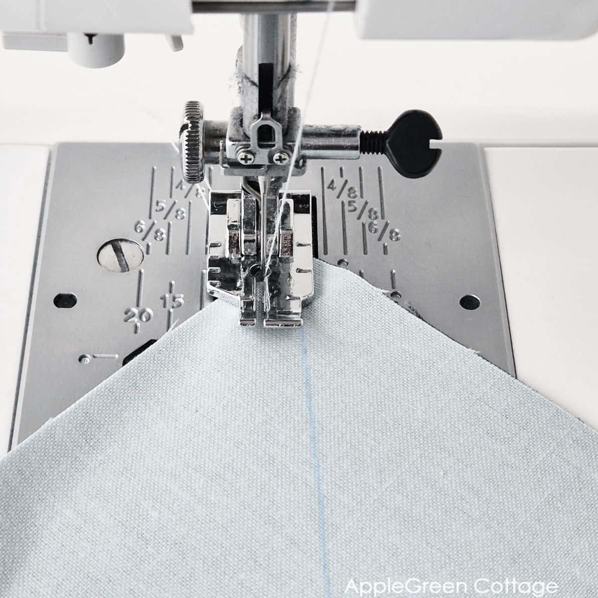 Sewing along the marked lines to create eight HSTs using the Magic 8 method.