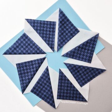 Half-square triangles laid out in a circleon light blue and navy background.