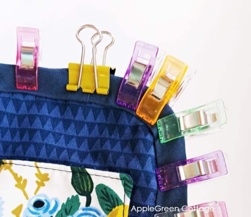 bag gusset in blue fabric with a zipper, attached to the main panel using sewing clips as pin alternatives.