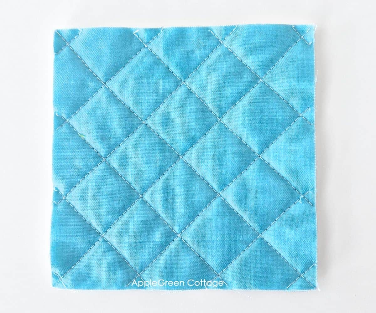 Crosshatch quilting on blue fabric – A simple, classic quilting design with diagonal intersecting lines for texture and stability.